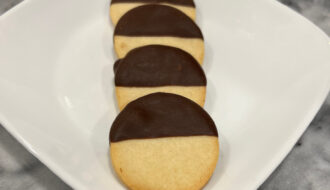 round black and white cookies displayed on a white plate