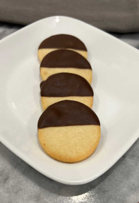 round black and white cookies displayed on a white plate