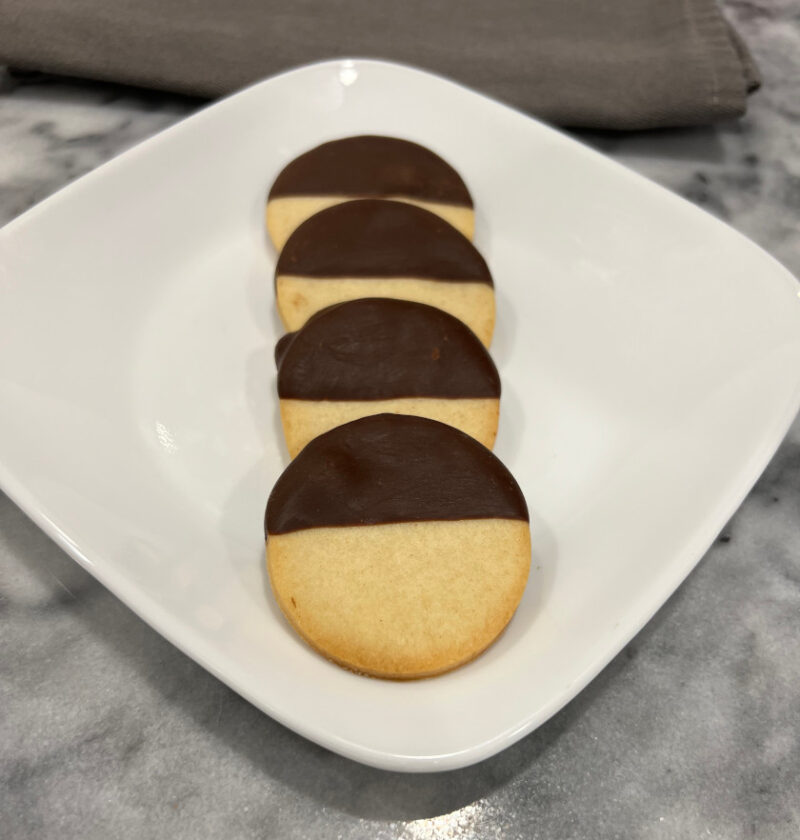 round black and white cookies displayed on a white plate